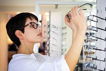 woman selecting a pair of glasses